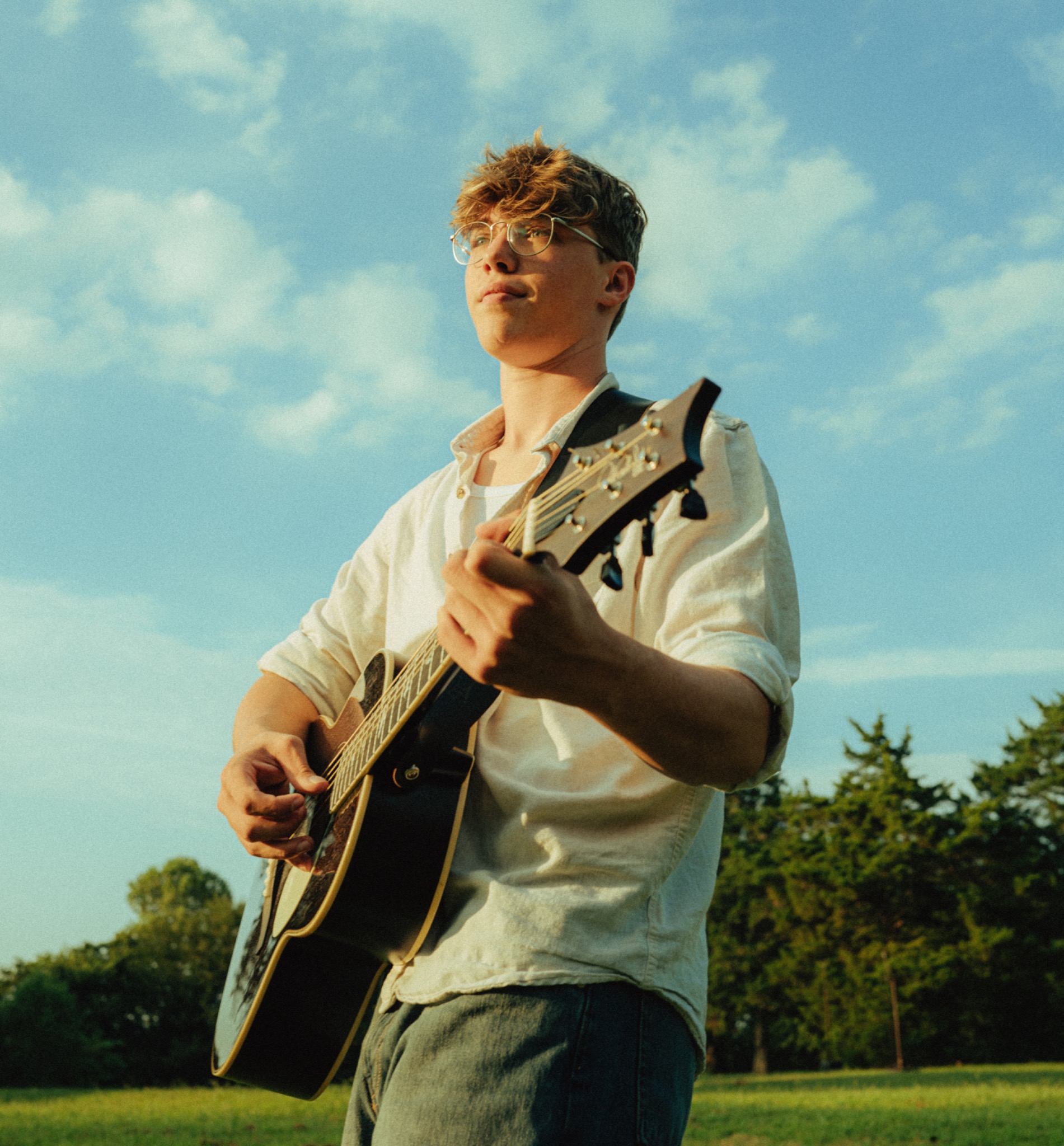 Kadin Alexander playing acoustic guitar outdoors